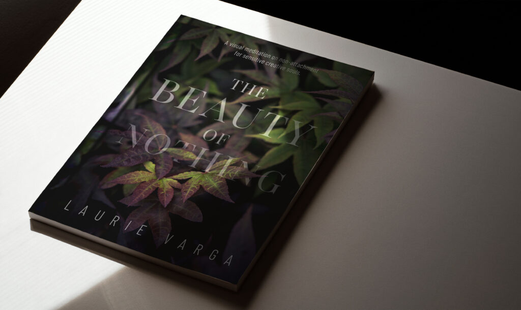 Hardcover book with Japanese maple leaves sitting on a white table.